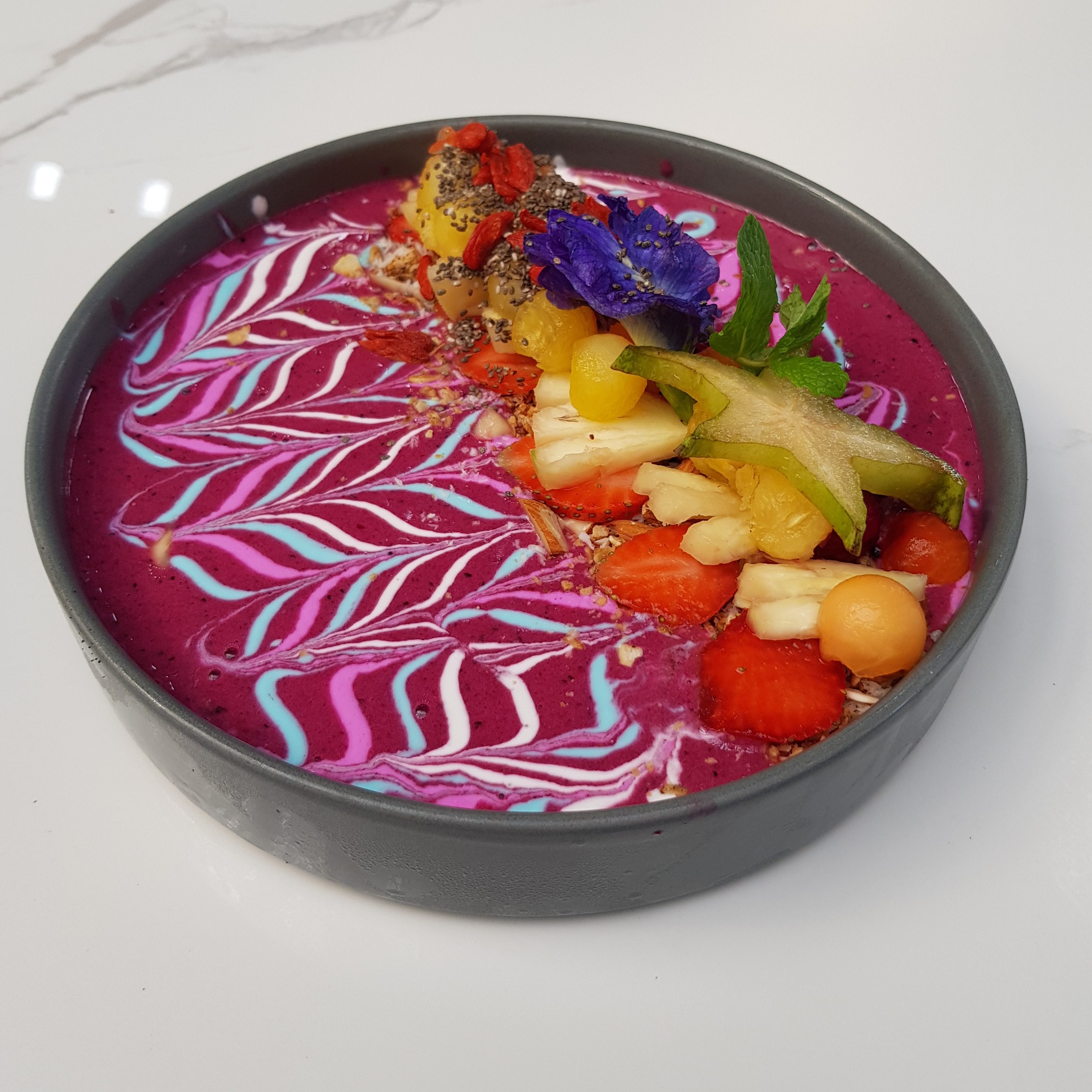 Fresh tropical fruits and healthy smoothie bowl in a café in Bali, ideal for digital nomads