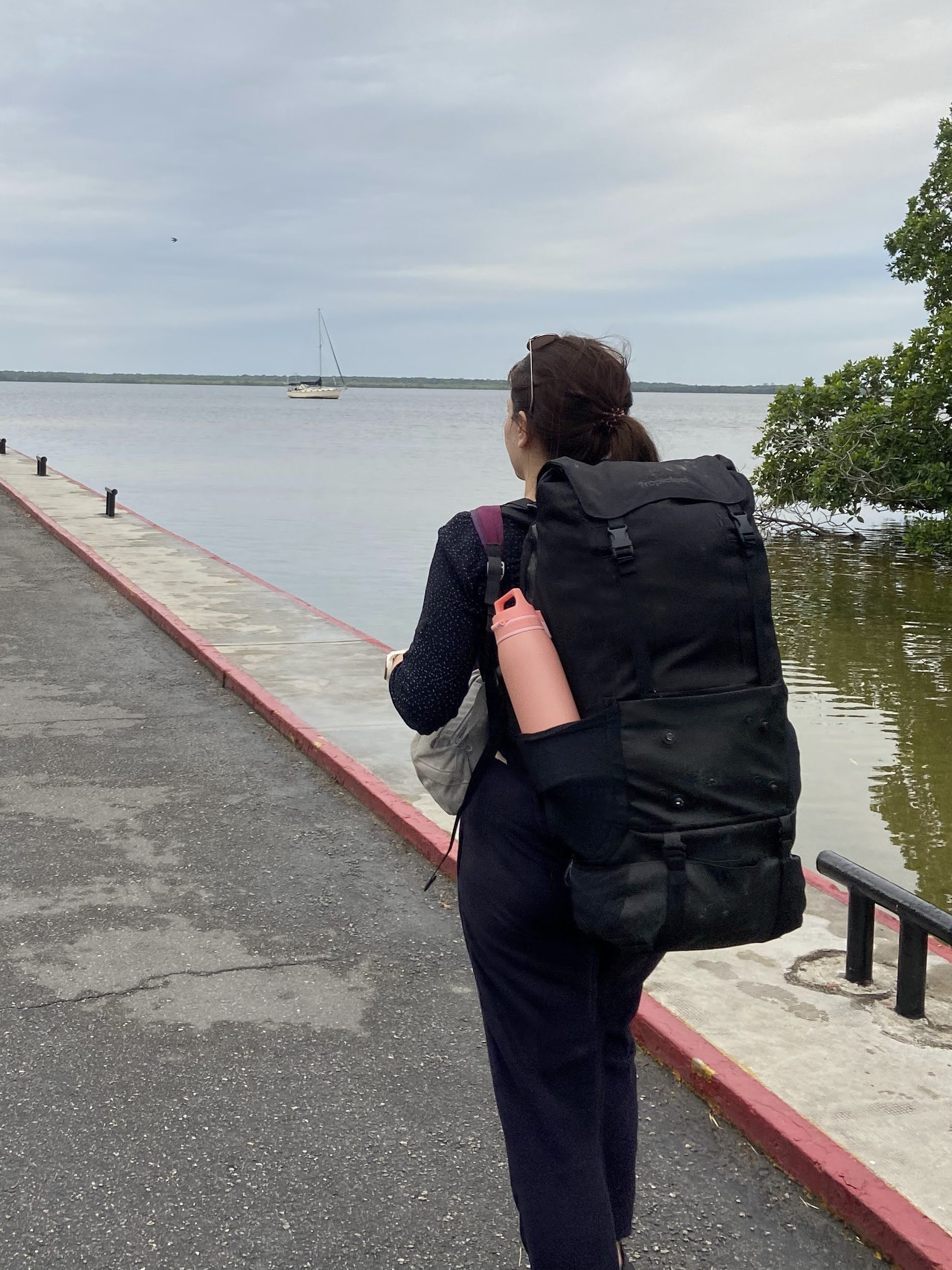 Backpacker crossing the border into Belize from Mexico with a large backpack, a common scene when facing backpacking problems.