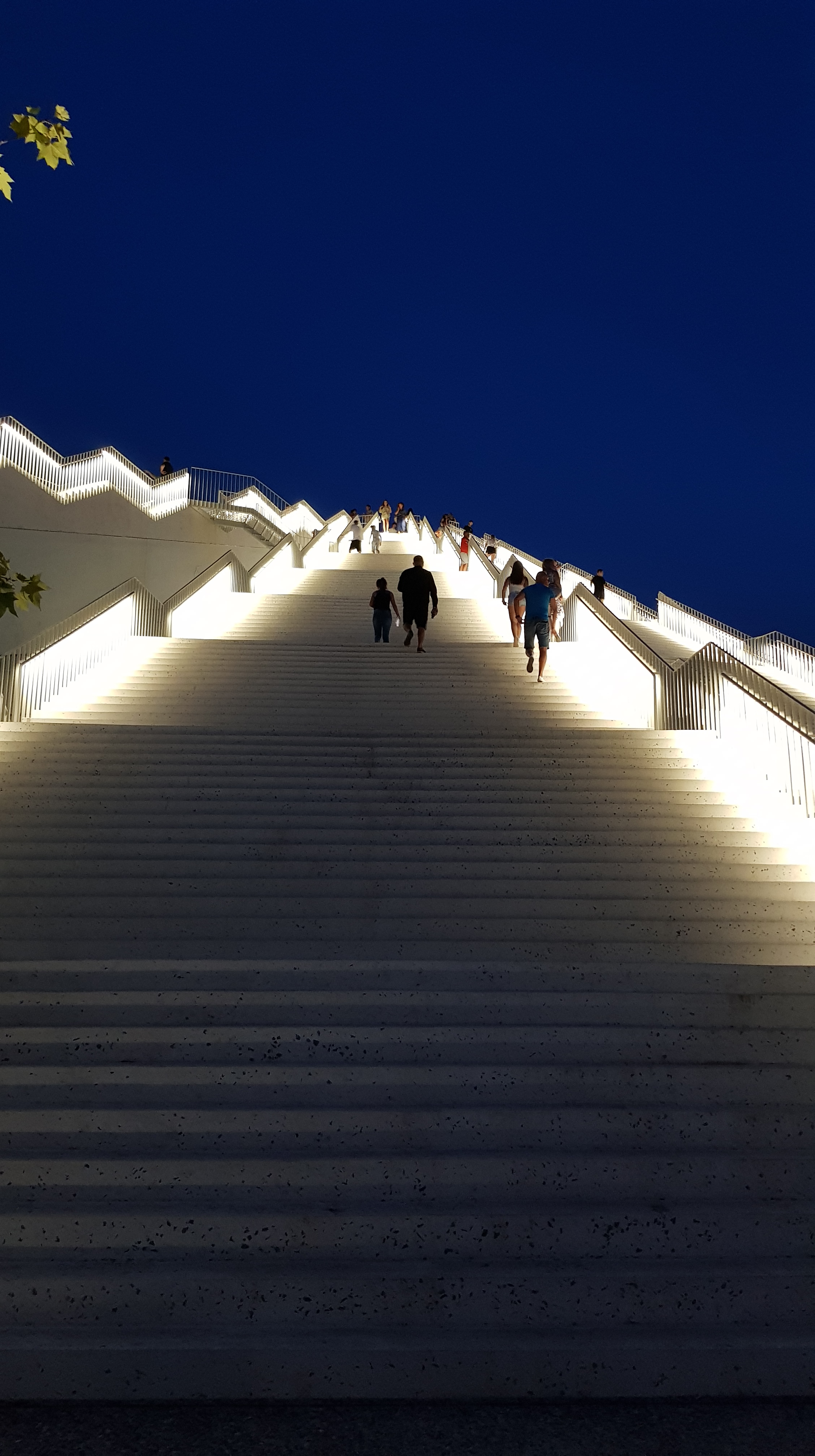 Staircase at night leading up to a modern building in Tirana, Albania, offering unique experiences for digital nomads.