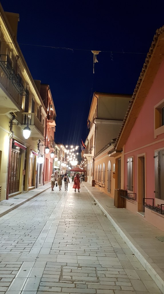 Nighttime view of a charming street in 'Little Italy' in Vlora, lined with Italian restaurants and cafes, reflecting the city's Mediterranean influence.