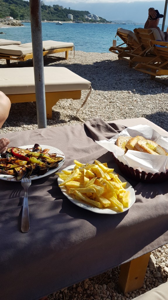 Lunch by the beach in Albania with grilled vegetables and fries, enjoyed by digital nomads on Kevi Beach.