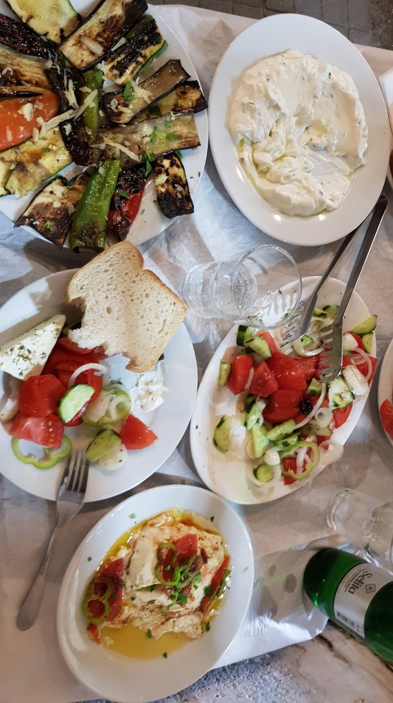 A spread of fresh Albanian dishes including grilled vegetables, salad, and feta cheese, perfect for enjoying the local flavors.