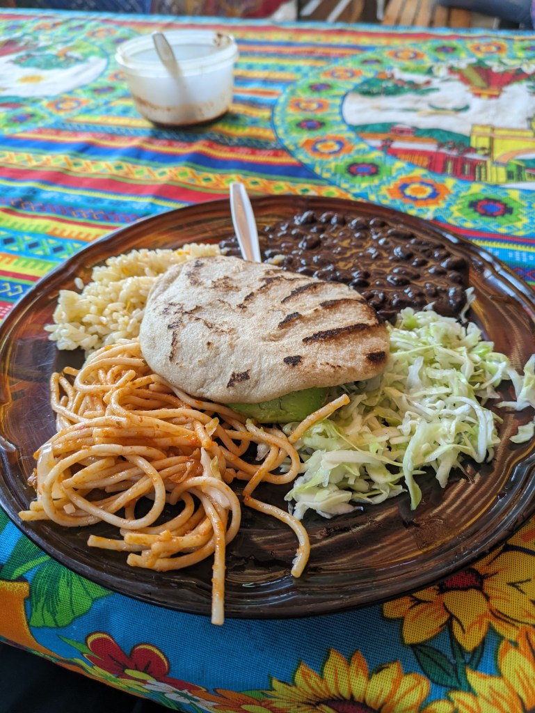 Traditional Guatemalan dish with black beans, pasta, and cabbage salad, a hearty meal for digital nomads