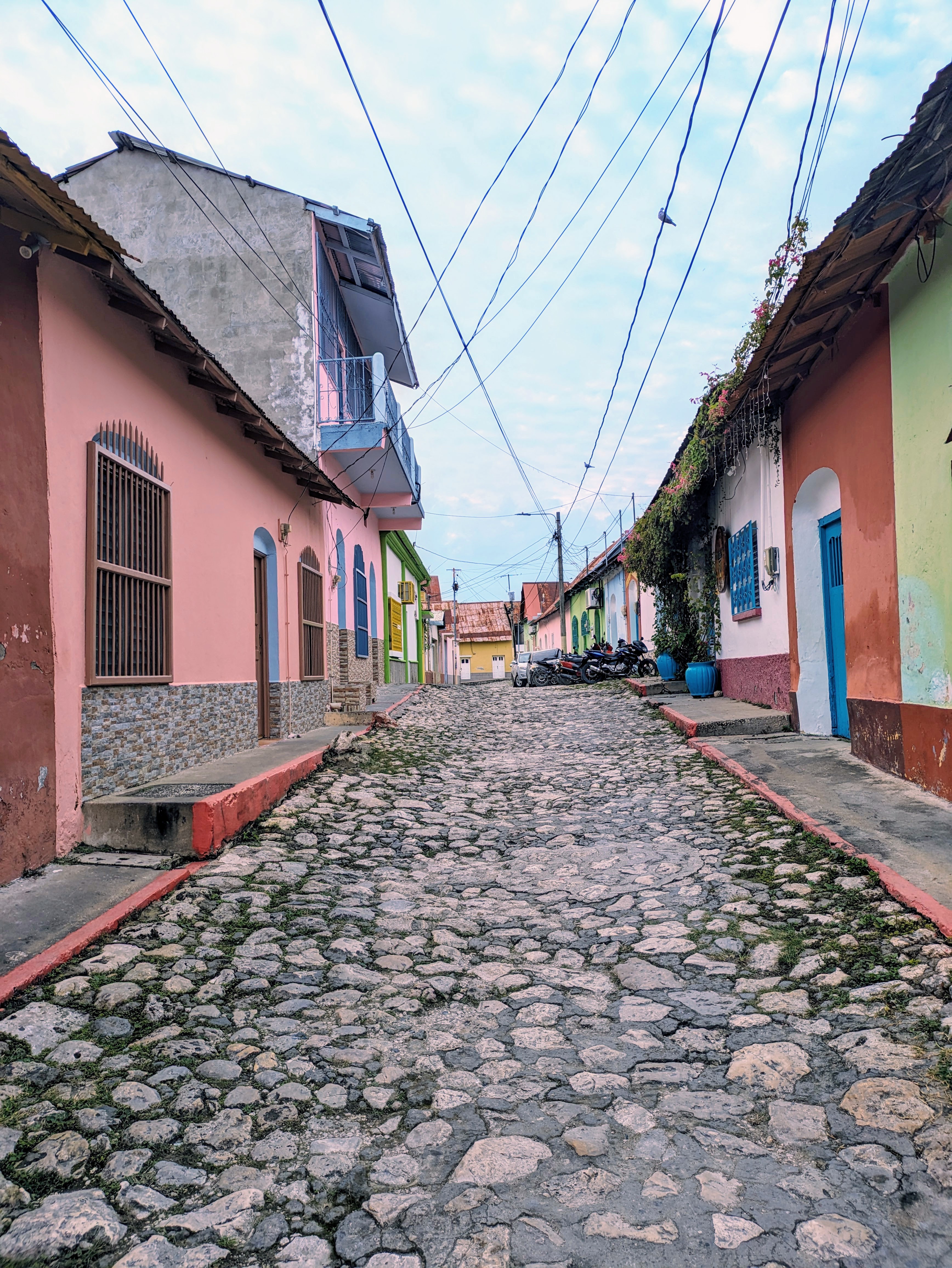 Cobblestone street lined with colorful houses in Flores, a picturesque destination for digital nomads in Guatemala.