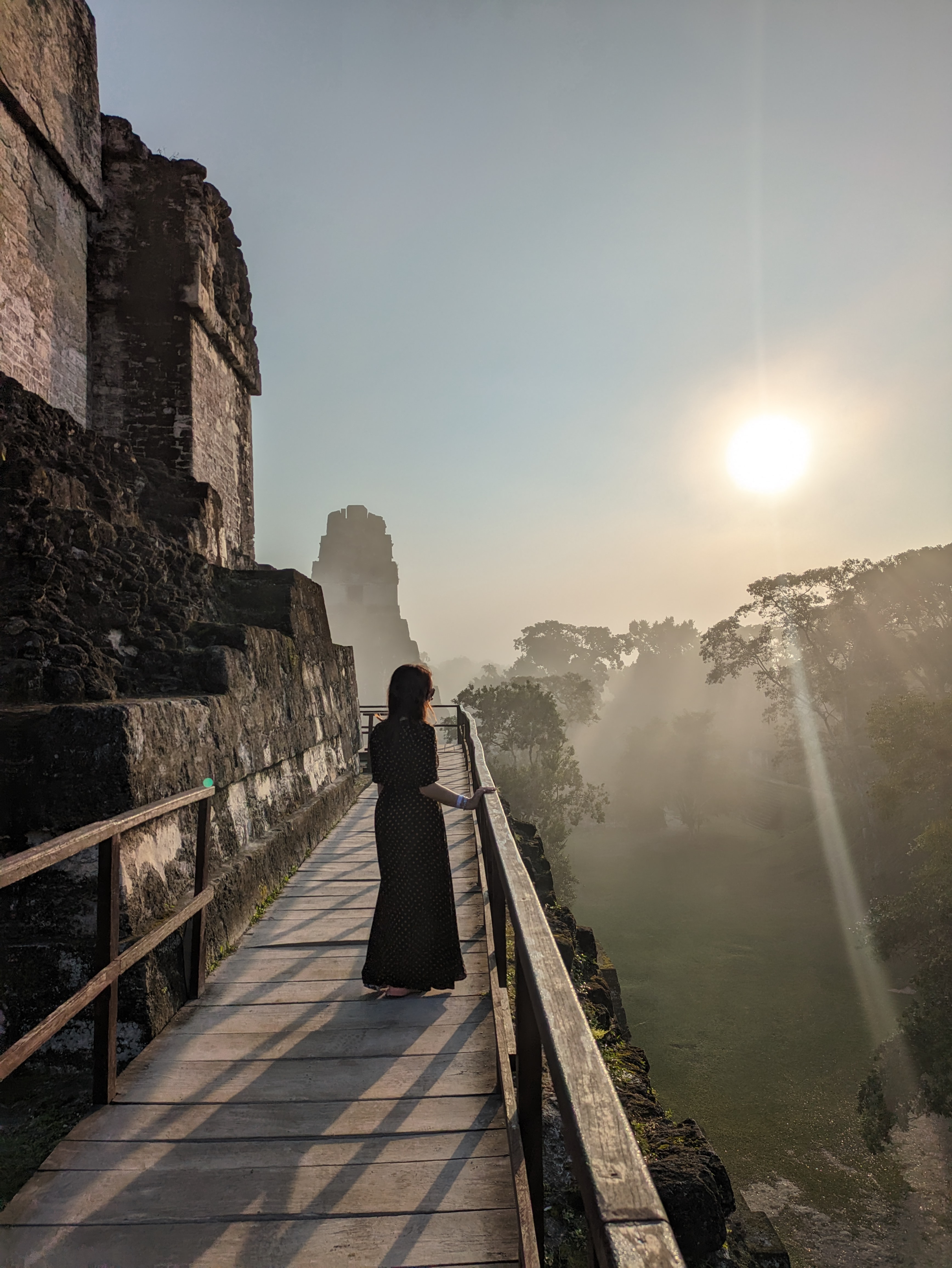 Digital nomad exploring ancient Mayan ruins at sunrise in Tikal, Guatemala.