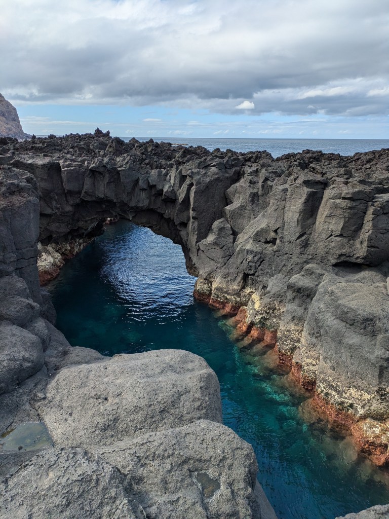 Volcanic rock formation and clear water at Ferraria, a perfect natural landmark for digital nomads in the Azores.