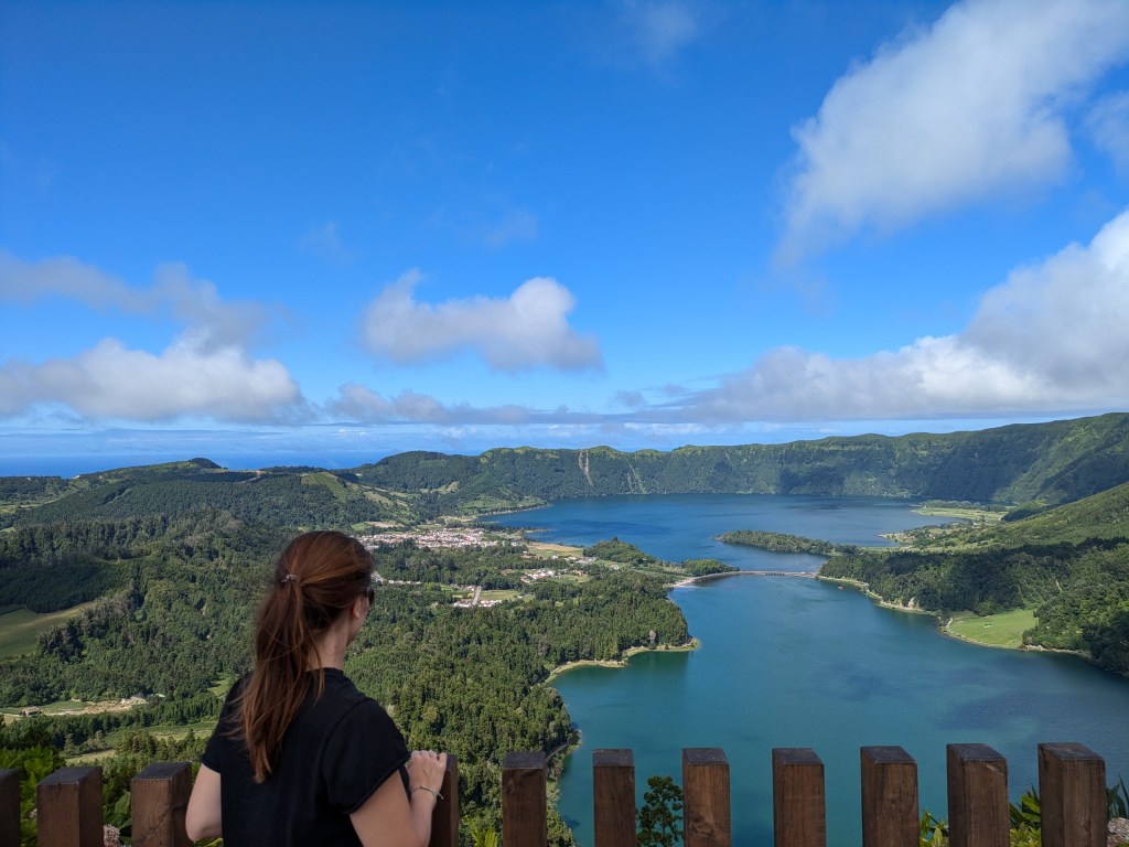 A digital nomad overlooking lush green lakes in the Azores, showcasing nature's role in "what is a digital nomad" life.
