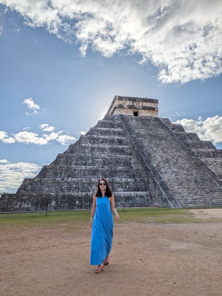 A digital nomad standing near Chichen Itza, a world-famous Mayan site, embodying "what is a digital nomad" exploration.