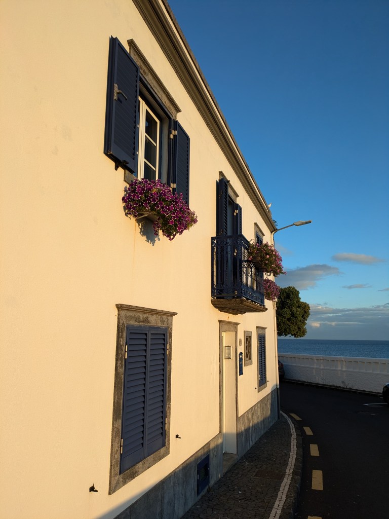 Traditional house with blue shutters and ocean view, a picturesque spot for digital nomads in the Azores.