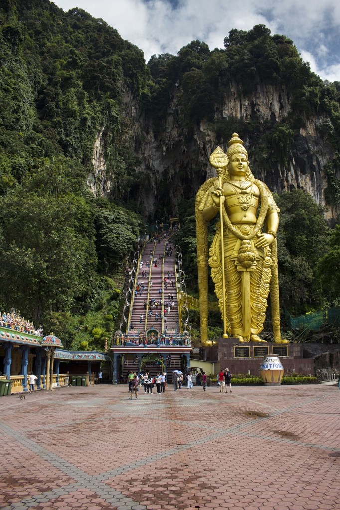 Golden statue of Lord Murugan at Batu Caves, a cultural landmark near Kuala Lumpur for digital nomads in Malaysia