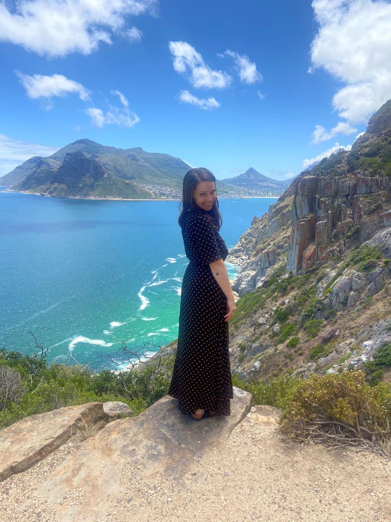 A digital nomad enjoying a scenic coastal view during a weekend trip in Cape Town, without backpacking problems.