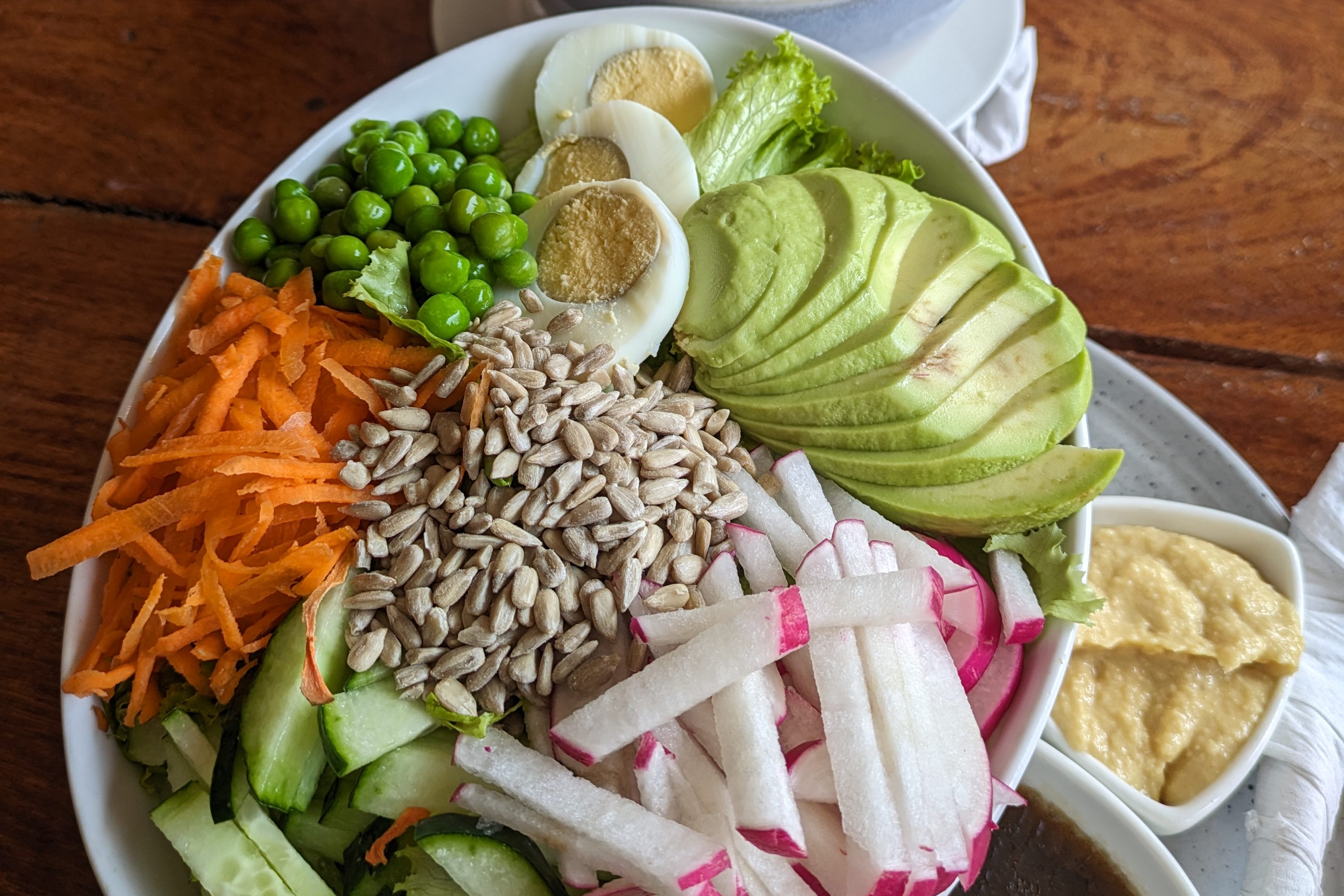 Healthy vegetarian bowl with avocado, boiled eggs, sunflower seeds, and fresh vegetables, addressing dietary backpacking problems while traveling