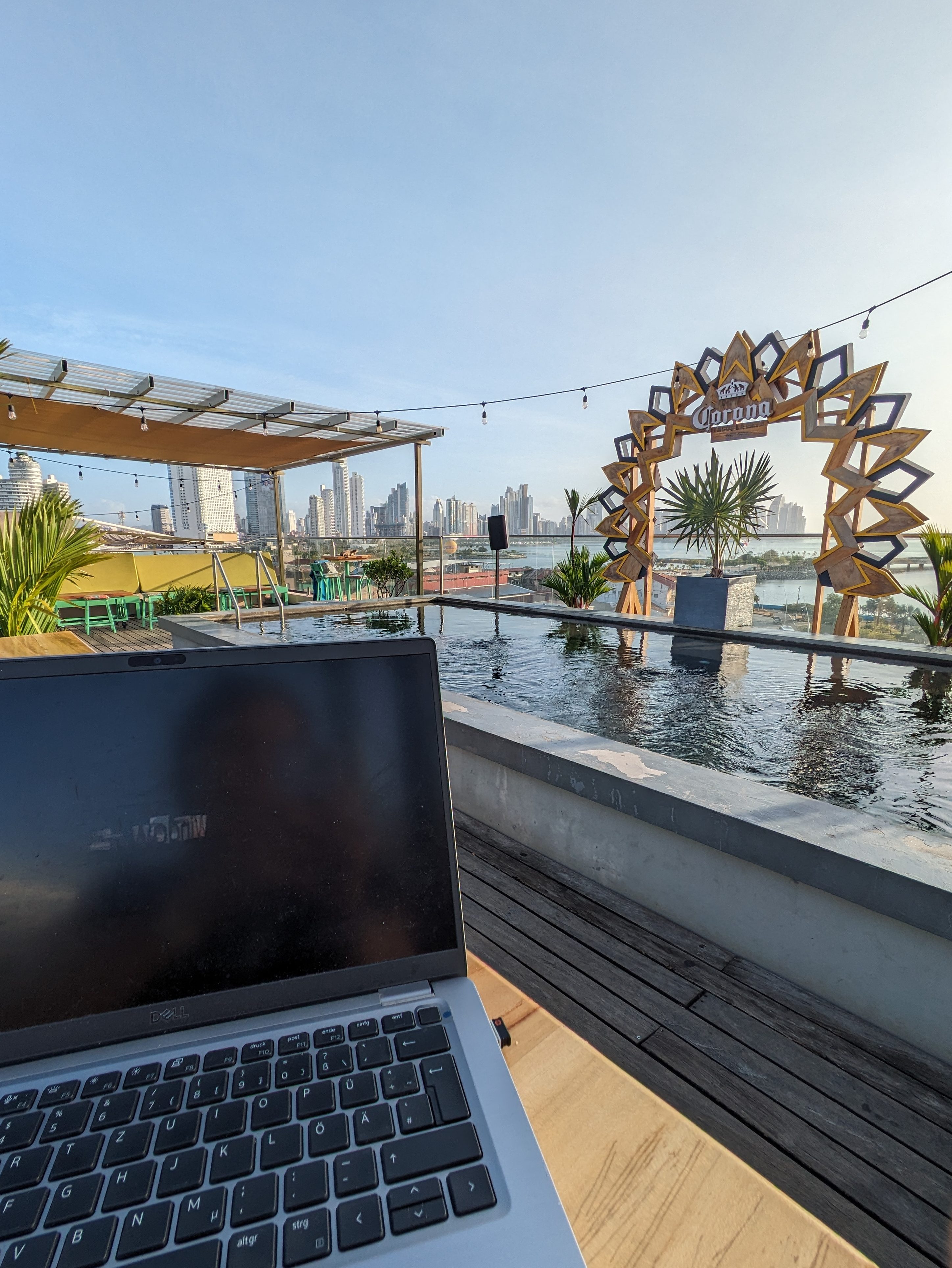 Laptop on a balcony overlooking Panama City rooftops, without backpacking problems.