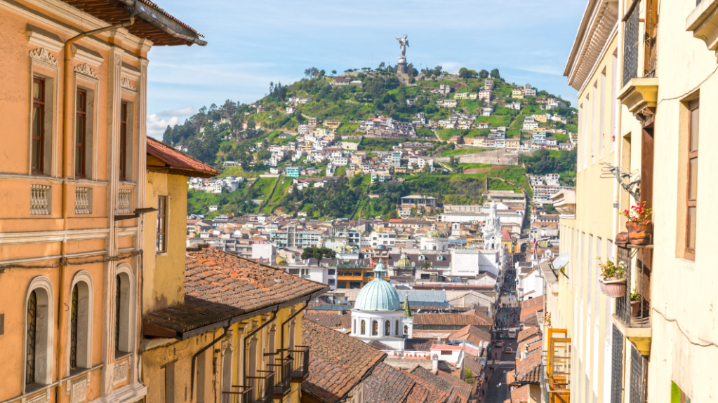 View of Quito's historic center and El Panecillo hill in Ecuador, carribean island with palm trees and small houses, without backpacking problems.