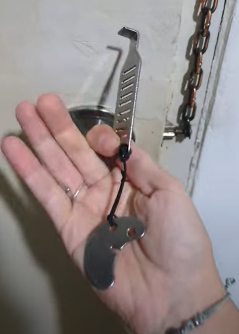 A person holding a stainless steel travel door lock designed for added security while traveling.