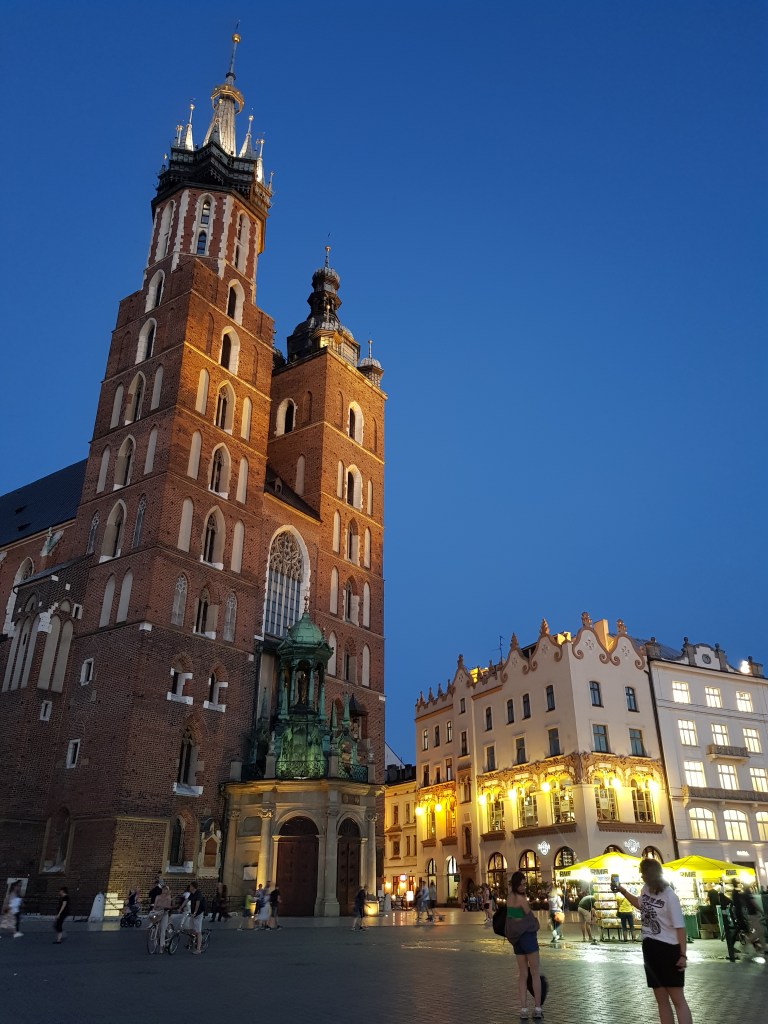 Krakow for digital nomads St. Mary’s Basilica illuminated at dusk in Main Market Square