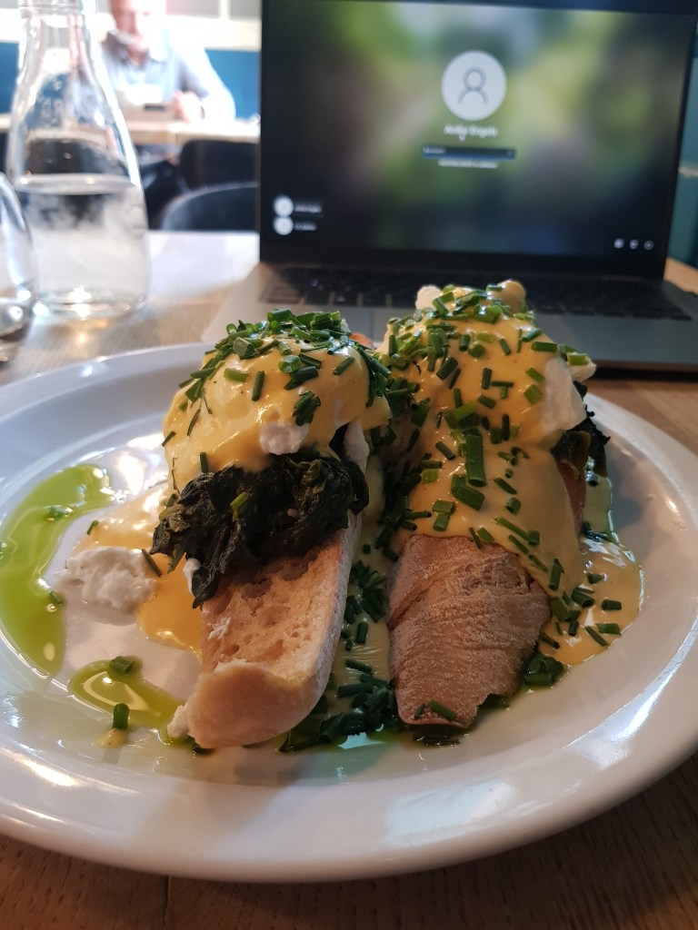 Laptop and egg benedict at a digital nomad café in Kraków